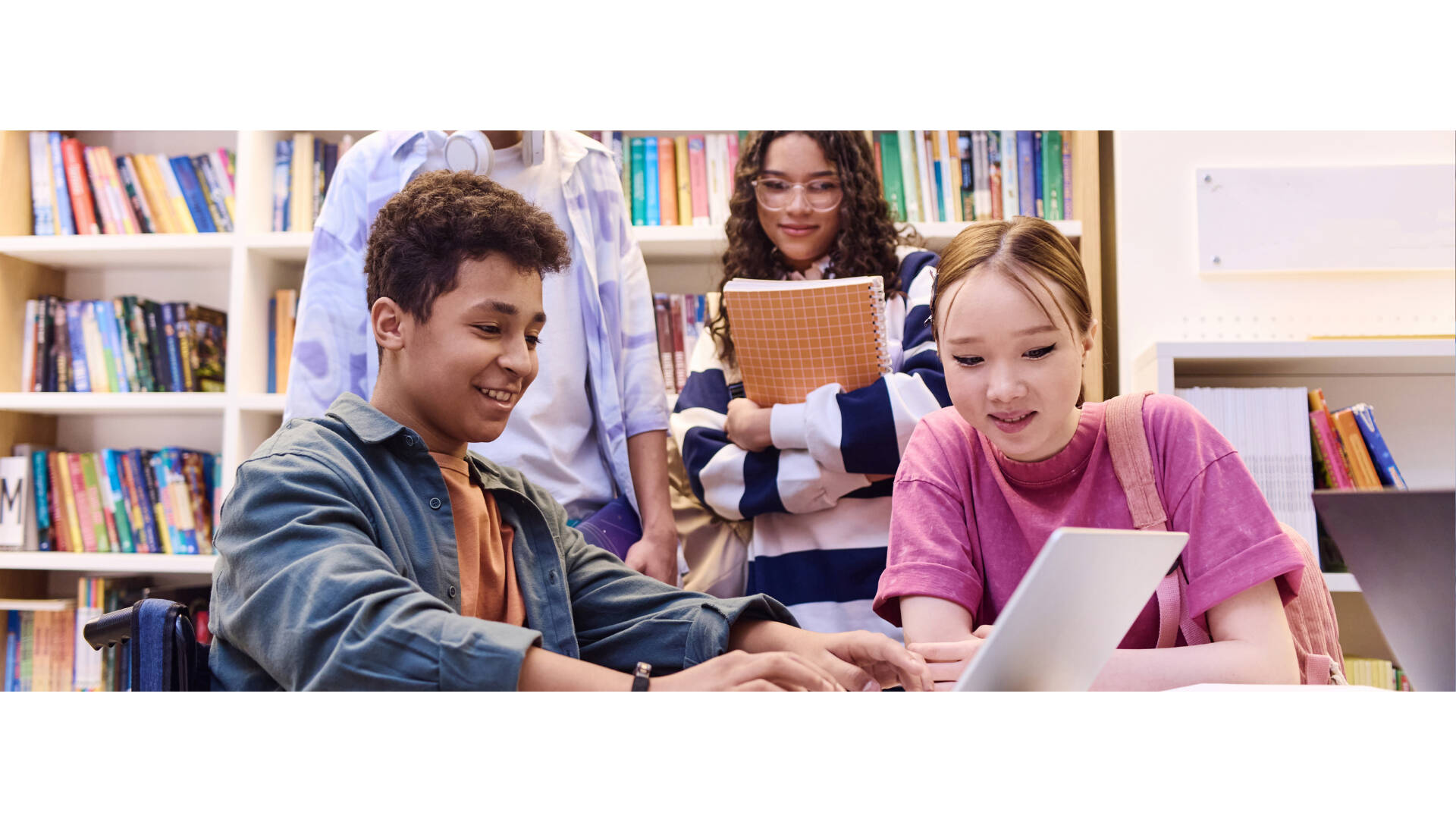 Four teenagers working on a computer together